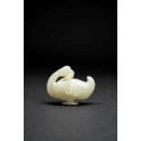 A CHINESE CELADON JADE CARVING OF A GOOSEQING DYNASTY OR LATERStanding holding a lotus stem in its