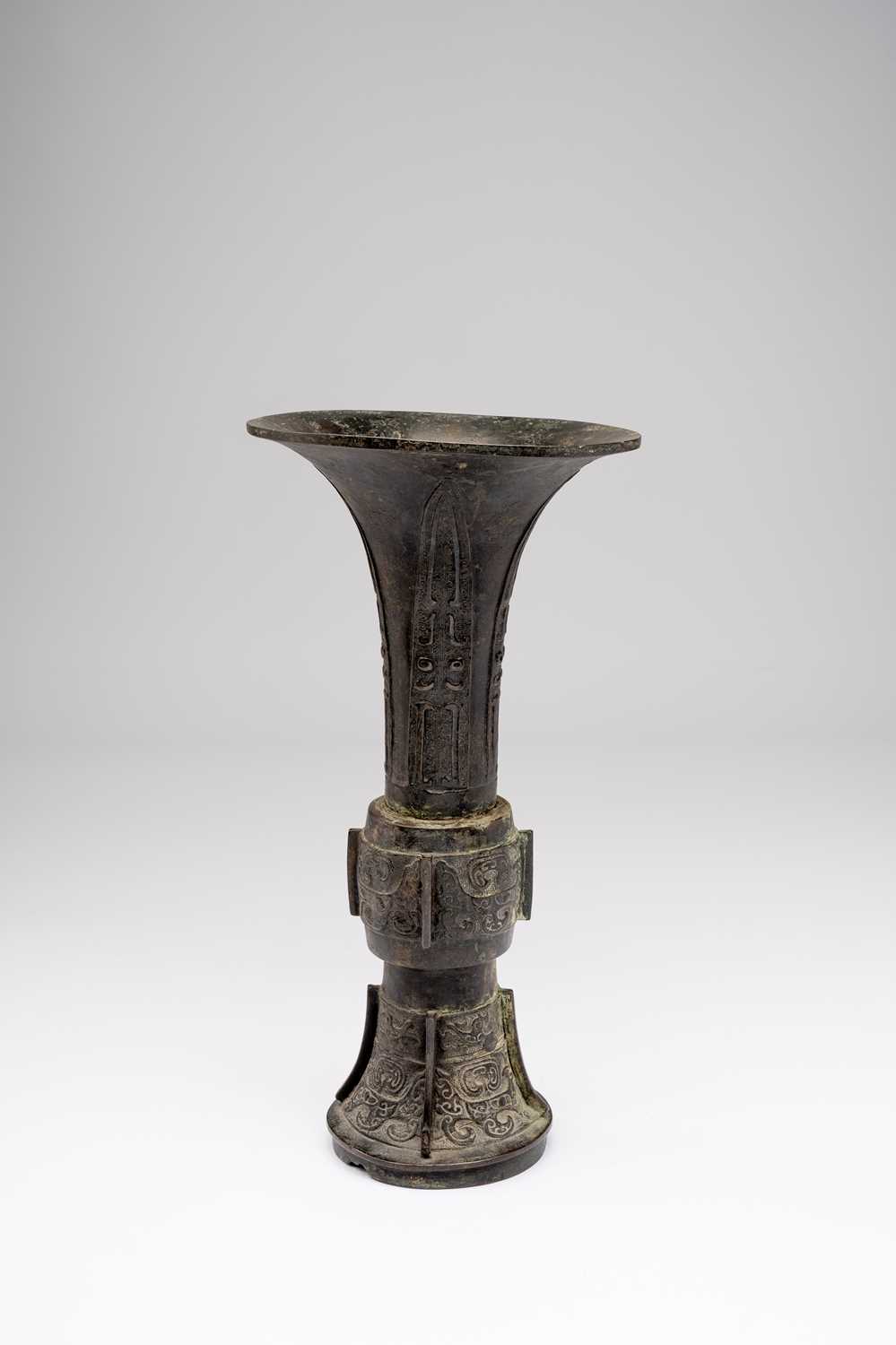 A CHINESE BRONZE ARCHAISTIC GU-SHAPE VASE17TH CENTURYThe central section and base cast with taotie