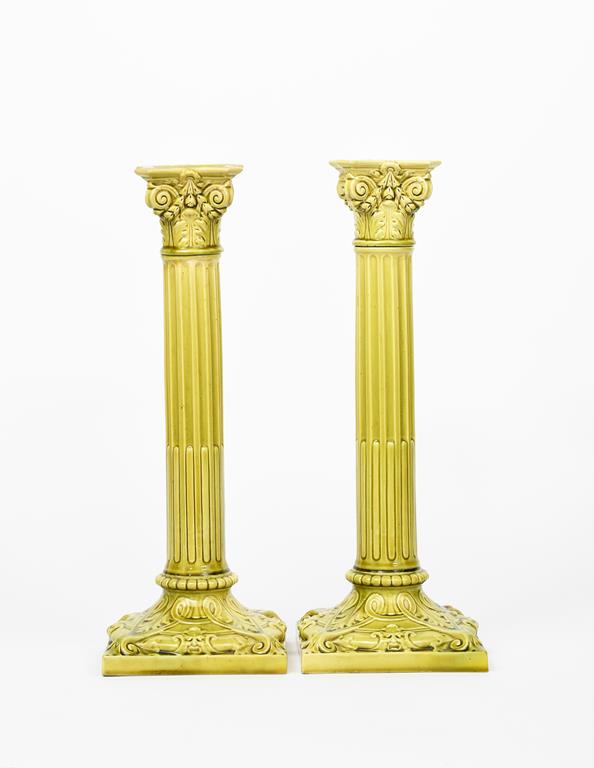 A pair of tall Burmantoft's Faience candlesticks, model no.1850, modelled as Corinthian pillars, the