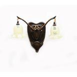 A pair of patinated bronze wall sconces, the shield shape backs cast with scroll motif, twin-