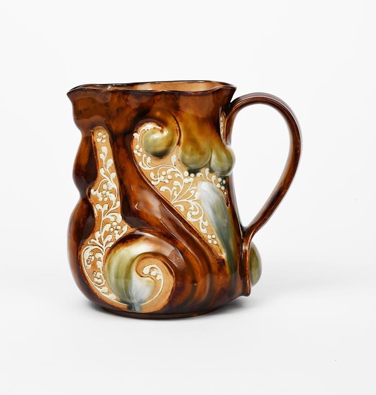 A Doulton Lambeth stoneware jug by Frank Butler, modelled in relief with scrolling foliage, glazed