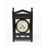 An Aesthetic Movement ebonised wood mantel clock in the manner of Lewis F Day, rectangular form with