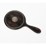 A silver mounted ebony hand mirror by Ernest Gimson for Nellie Gimson, circular the back set with