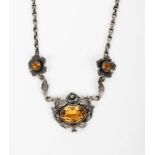 A silver and citrine necklace possibly Australian, the simple drop with foliate border and central