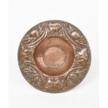 A repousse copper plate by John Pearson, dated 1902, hammered to the rim with a frieze of masks