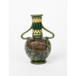 A Burmantoft's Faience Partie-Colour twin-handled vase, 'slip' decorated in low relief with a
