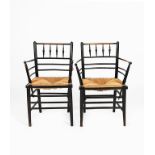 A pair of Morris & Co Sussex armchairs, ebonised wood with rush seat, unsigned, 85cm. high, (2)