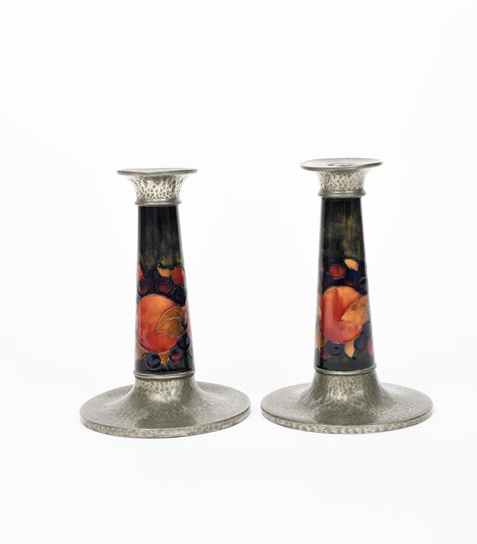 Pomegranate a pair of Moorcroft Pottery candlesticks with Tudric Pewter mounts designed by William