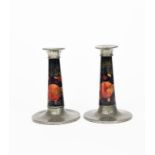 Pomegranate a pair of Moorcroft Pottery candlesticks with Tudric Pewter mounts designed by William