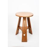 A Liberty & Co oak occasional table, circular top with flaring tripod legs, with pierced dash and