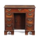 AN EARLY GEORGE III MAHOGANY KNEEHOLE DESK C.1760 the top with a caddy moulding and re-entrant front