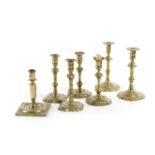 A PAIR OF BRASS CANDLESTICKS EARLY 18TH CENTURY each with a foliate nozzle, above a knopped stem and