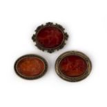 A collection of carnelian intaglio brooches, comprising three brooches, each set with an oval