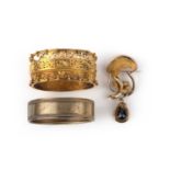 Two Victorian bangles and a garnet brooch, comprising: a hinged gold bangle, the front of scrolled
