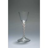 A small colour twist wine glass, c.1765, the round funnel bowl raised on a stem enclosing opaque
