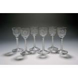 A matched set of six small wine glasses, c.1760, the ogee bowls engraved with simple flower