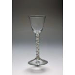 A small colour twist wine glass, c.1765, the round funnel bowl raised on a stem with spiral gauze