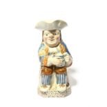 A Pratt ware Toby jug, c.1790, decorated in blue, ochre and umber, wearing an elaborately striped