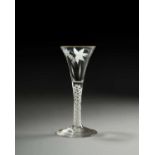 An unusual Beilby wine glass, c.1770, the drawn trumpet enamelled in white with a spray of