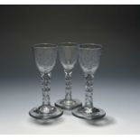 A pair of small wine glasses, c.1770, the round funnel bowls engraved and polished with rose and