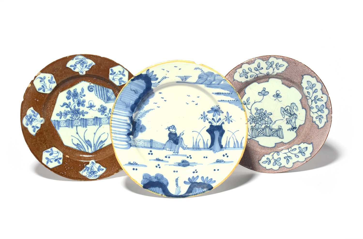 Three delftware plates, c.1750-70, one probably London and painted with an ornamental fence in an