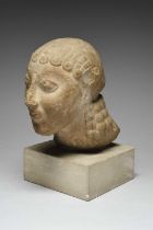 A Greek Archaic style marble head of a kouros with large almond shape eyes, straight nose and pursed