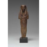 An Egyptian wood shabti New Kingdom, 18th Dynasty, circa 1320 BC with a tripartite wig and crossed