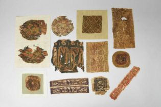 Twelve Coptic textile fragments circa 5th century AD depicting figures, animals and foliage, the