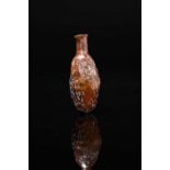 A Roman amber glass date flask circa 1st - 2nd century AD mould blown with a cylindrical neck and