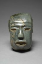 A Mexican mask aventurine, in Olmec style with recessed eyes and an open mouth, the back with