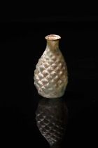 A Roman pale green glass pine cone flask circa 2nd - 3rd century AD the body blown in a two part