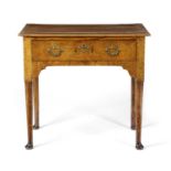 A GEORGE II WALNUT LOWBOY C.1735 the crossbanded top above a frieze drawer, on turned legs and pad