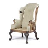 A MAHOGANY WING ARMCHAIR IN GEORGE II STYLE, 19TH CENTURY the flat topped back above scroll arms,