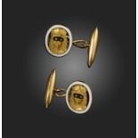 A pair of gold and enamel cufflinks, each designed as a lady in a Harlequin mask in black enamel,