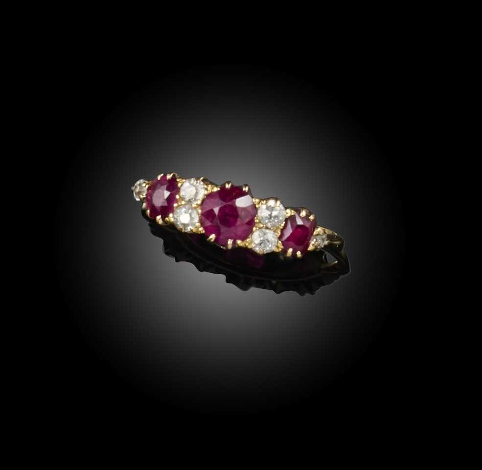 A ruby and diamond ring, early 20th century, set with three circular-cut rubies, spaced by