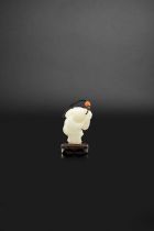 A CHINESE WHITE JADE FIGURE OF A BOY HOLDING A LARGE LOTUS BRANCH QIANLONG 1736-95 He smiles and