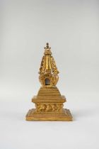 A TIBETAN GILT-BRONZE MODEL OF A STUPA 19TH/20TH CENTURY The dome to the centre decorated with