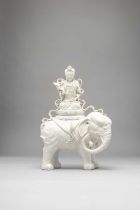 A LARGE CHINESE WHITE GLAZED MODEL OF GUANYIN SEATED ON THE BACK OF A CAPARISONED ELEPHANT QING