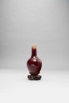 A CHINESE FLAMBE GLAZED BOTTLE VASE 18TH CENTURY The deep red glaze thinning to pale celadon