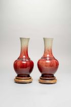 A PAIR OF CHINESE FLAMBE GLAZED BOTTLE VASES 19TH CENTURY The deep red glaze thinning to pale