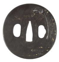 A Japanese sword guard (tsuba), iron with relief decoration and gilt details, a monkey in a tree