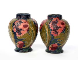 A pair of Bursley Ware Seed Poppy vases designed by Charlotte Rhead, shouldered form, tubeline