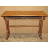 A vintage wooden school desk for two pupils raised on square cut and moulded jointed supports, 110