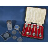 A cased set of six silver teaspoons, a silver hand mirror and blusher, a silver capped glass bottle,