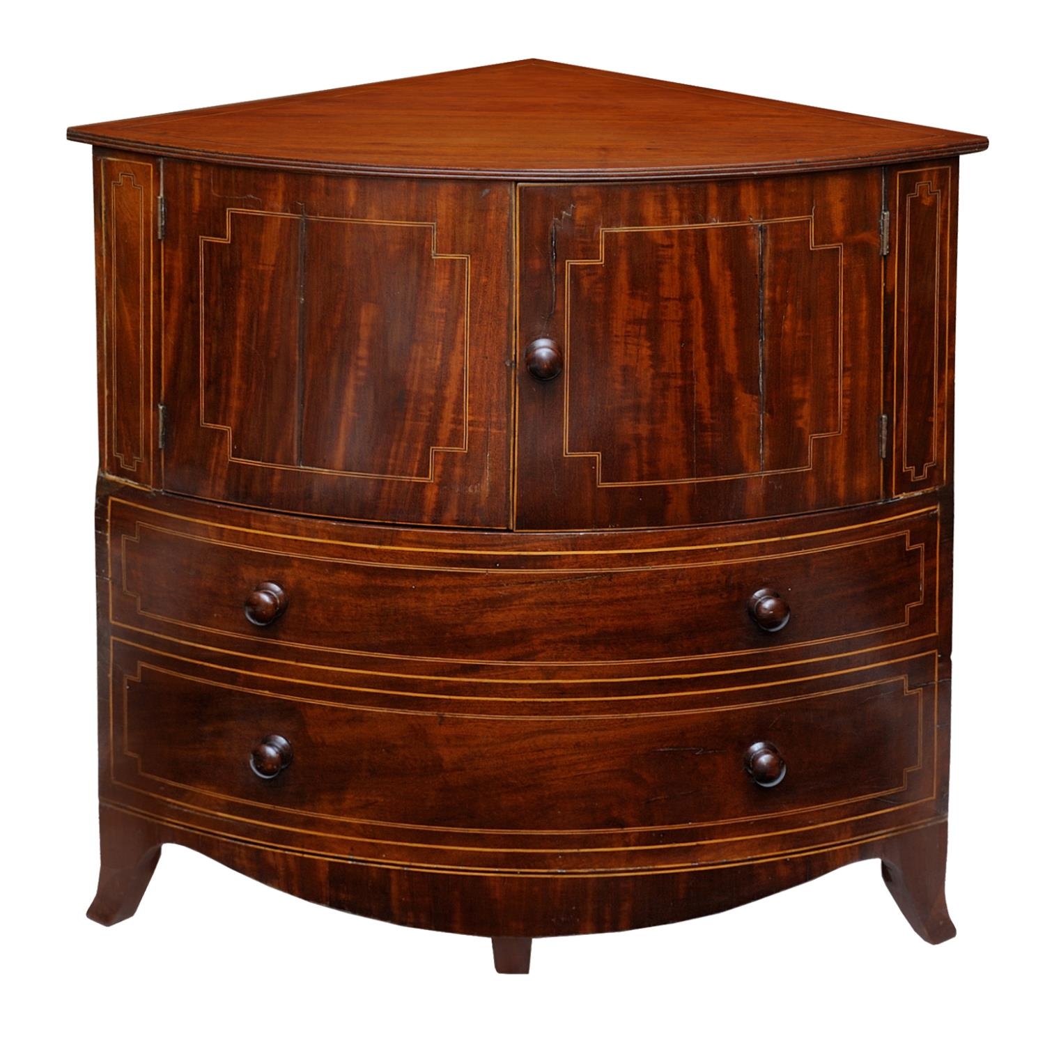 A Georgian mahogany corner commode with rising lid, with bowfronted outline, the front elevation