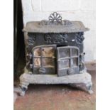 A large contemporary cast wood burning stove with decorative finish, 76 cm wide x 48 cm deep (not