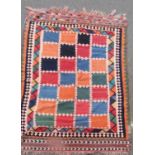 A Persian kilim runner with an overall multicoloured square panel design, 255cm x 146cm approx.