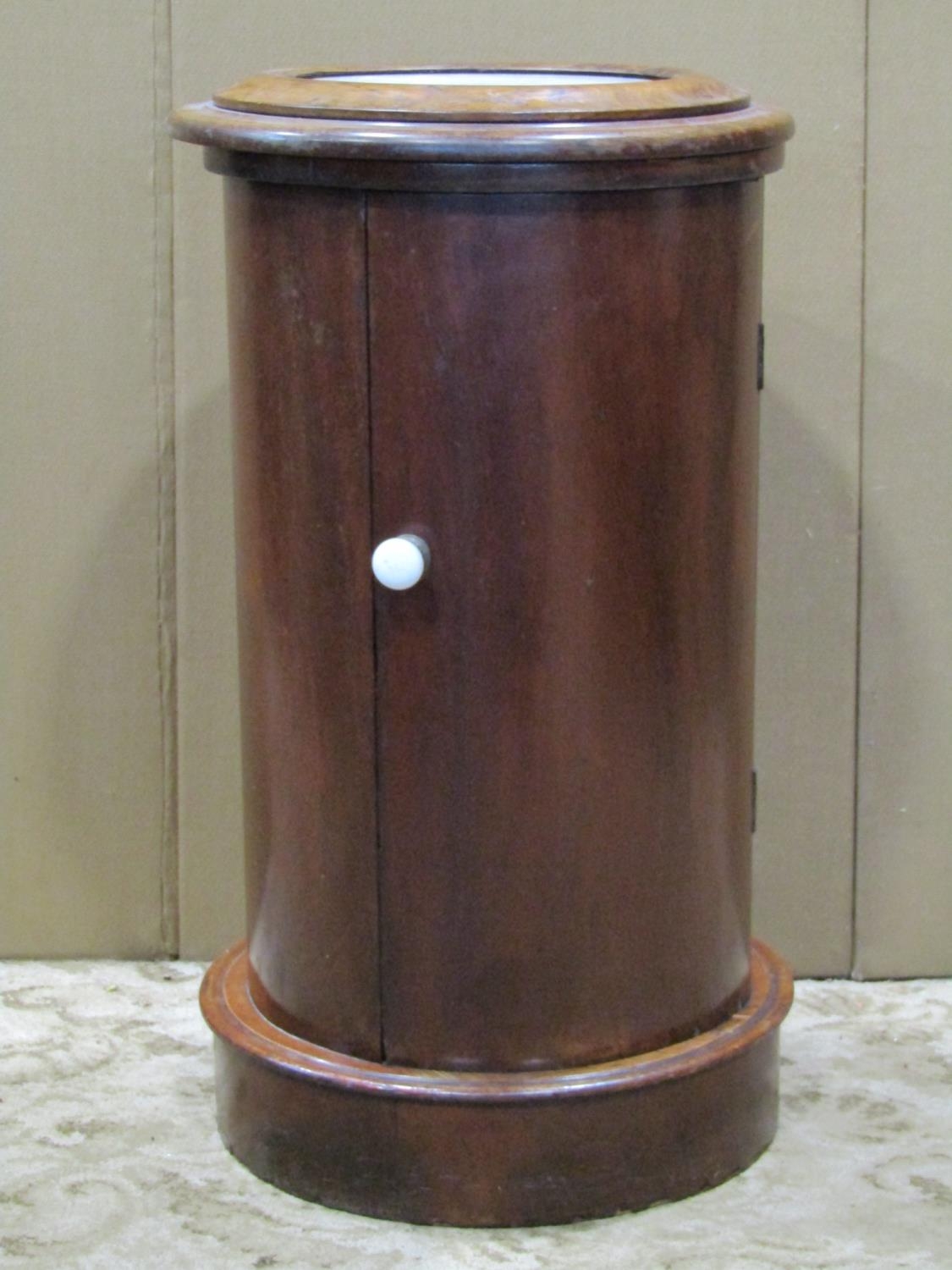 An unusual Victorian mahogany cylindrical pot cupboard, the hinged inset marble top enclosing a