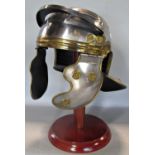 A reproduction Roman soldier's helmet with cheek and neck guard, steel with brass overlay