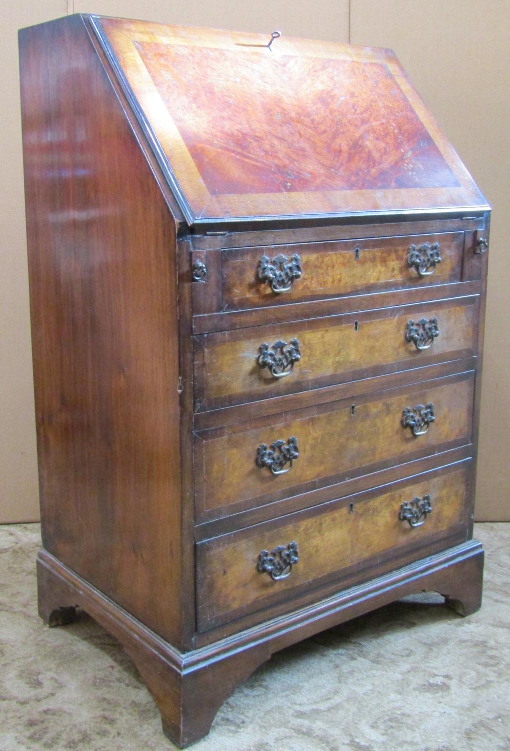 A small reproduction Georgian style walnut veneered and crossbanded writing bureau, the fall flap